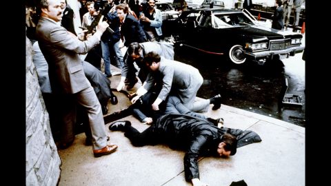 Police and Secret Service agents react during <a href="http://www.cnn.com/2013/07/17/us/gallery/crimes-of-the-century-reagan/index.html">the Reagan assassination attempt,</a> which took place March 30, 1981, after a conference outside the Hilton Hotel in Washington. Lying on the ground in front is wounded police officer Thomas Delahanty. Brady is behind him, also lying face down.