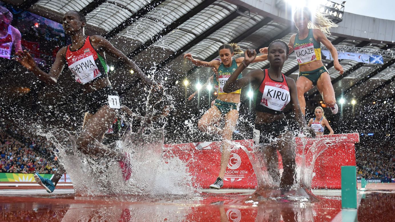 Kenya's Purity Cherotich Kirui and Milcah Chemos Cheywa lead runners through a water jump in the final of the 3,000-meter steeplechase Wednesday, July 30, at the Commonwealth Games in Glasgow, Scotland. Kurui won the event while Cheywa took silver.