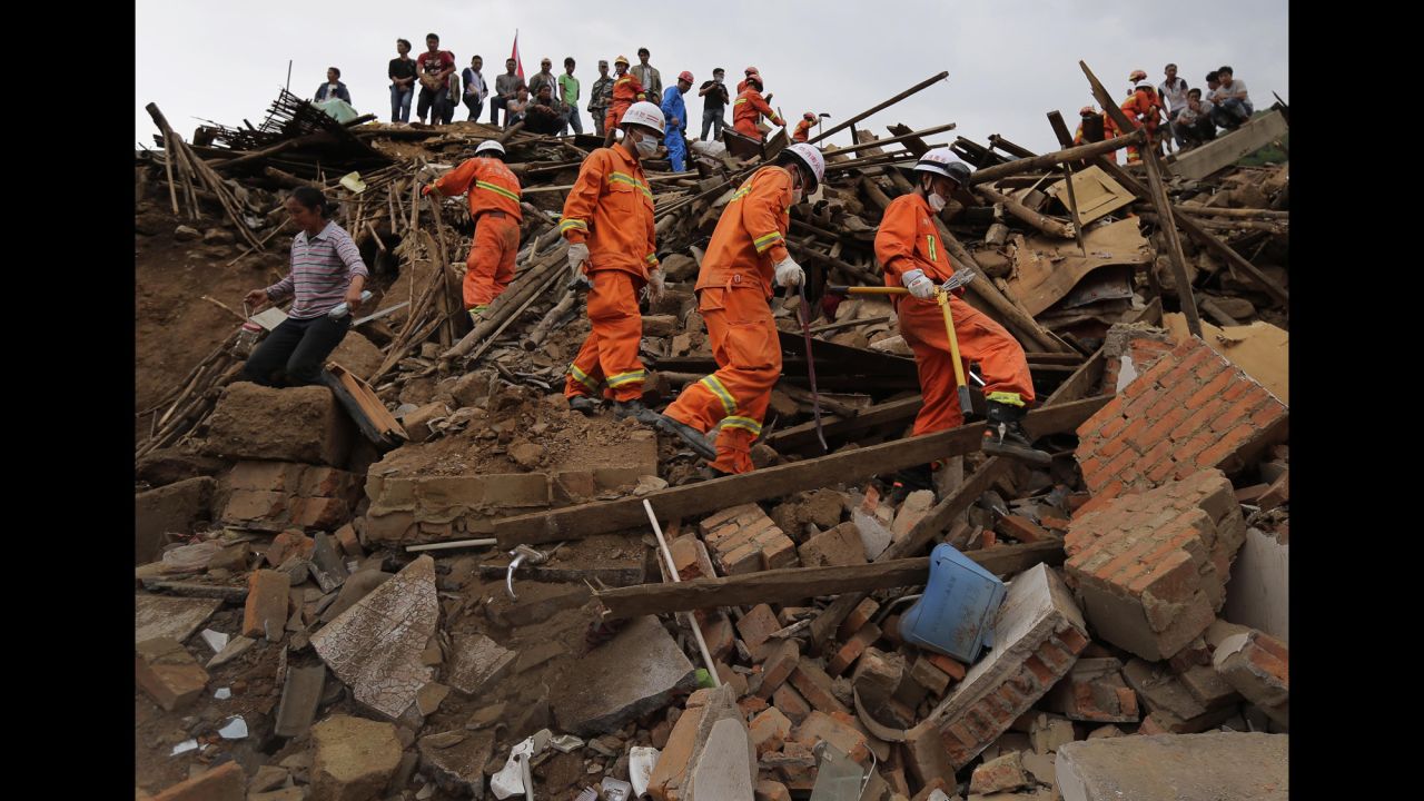 Rescue workers walk over rubble in Longtoushan on August 5.