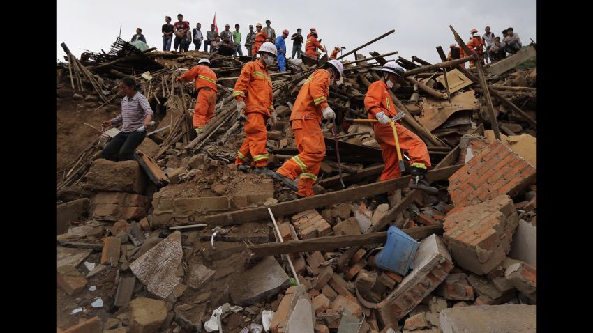 Rescue workers walk amongt the rubble in Longtoushan on August 5.