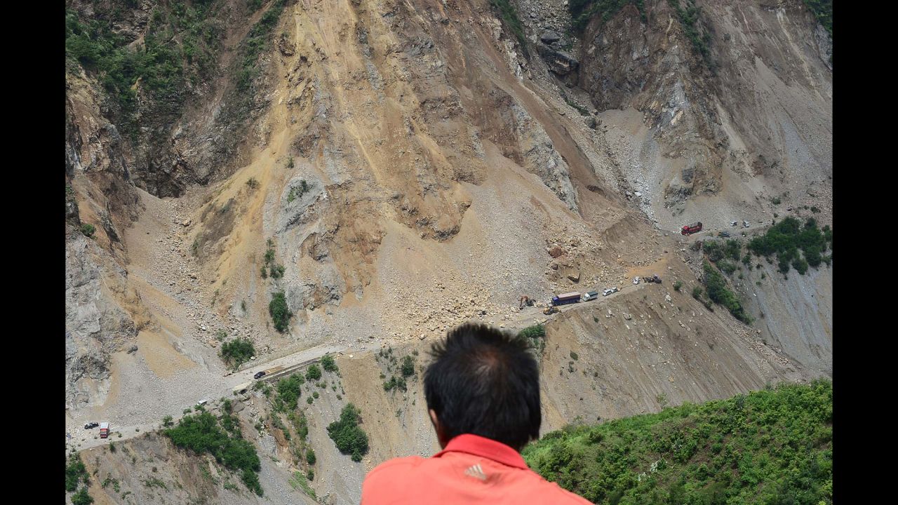 A man looks at a road buried by a landslide in Zhaotong, China, on Monday, August 4, a day after the earthquake.