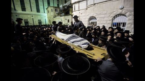 The body of Avrohom Wallis is carried during his funeral in Jerusalem on Monday, August 4. Wallis was killed in what Israeli police spokesman Micky Rosenfeld called a "terror attack," when a man drove an earthmover into a bus in Jerusalem.