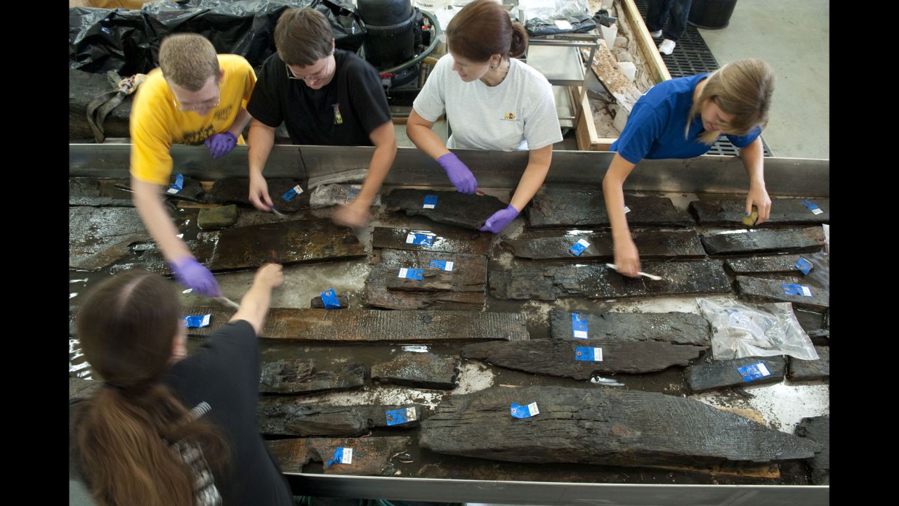 Volunteers and curators from the Maryland Archeological Conservation Laboratory clean timbers from the ship in August 2010. For more than 200 years, the ship was beneath New York City's World Trade Center.