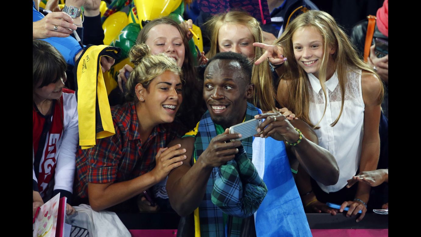 Jamaican sprinter Usain Bolt takes a selfie with fans after he and his team won the 4x100-meter relay Saturday, August 2, at the Commonwealth Games in Glasgow, Scotland.