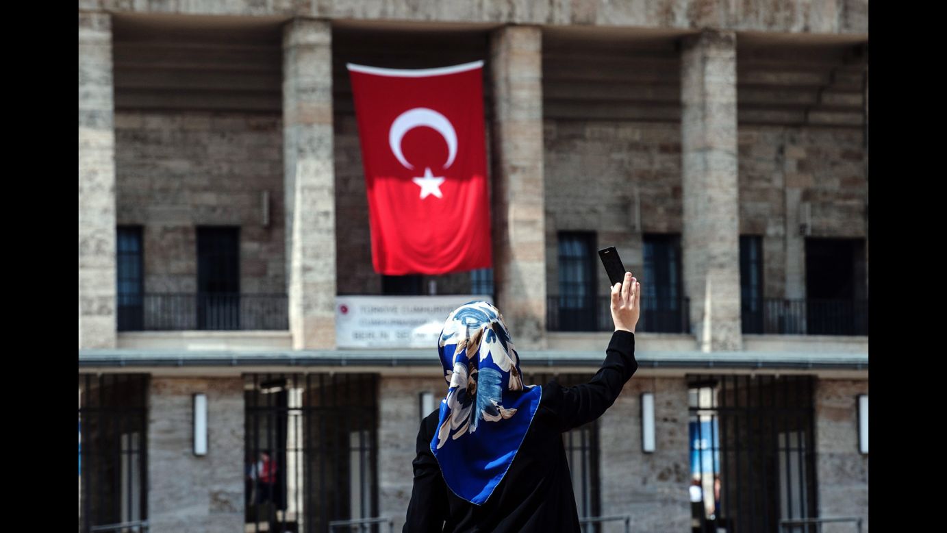 A woman takes a selfie in front of the Olympic Stadium in Berlin, which had a Turkish flag on it Sunday, August 3. For the first time, Turkish nationals in Germany were able to cast a vote in the Turkish presidential elections.