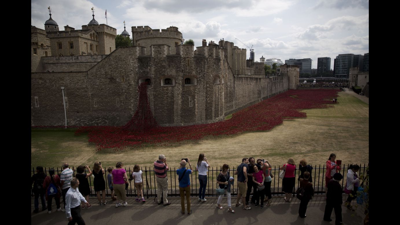 People pose for a selfie Tuesday, August 5, in front of the Tower of London, where <a href="http://www.cnn.com/2014/08/04/europe/gallery/tower-of-london-art-installation/index.html">a special art installation</a> is being built to commemorate the 100th anniversary of World War I. There will be 888,246 ceramic poppies planted, one for each British military member that died during the war. The installation, called "Blood Swept Lands and Seas of Red," was created by artist Paul Cummins.