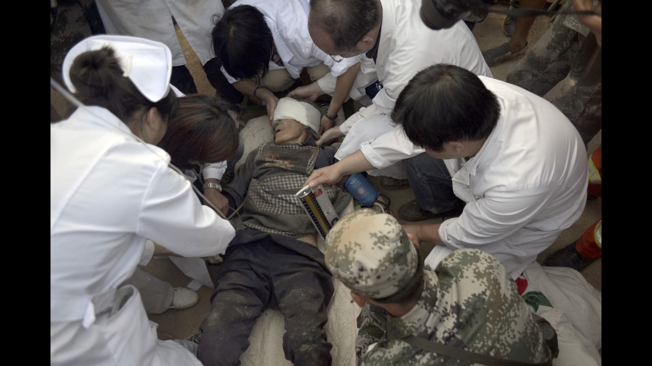 Survivor Xiong Zhengfen, 88, is treated by medical personnel on Tuesday, August 5, after being buried under rubble for 50 hours in Ludian County.