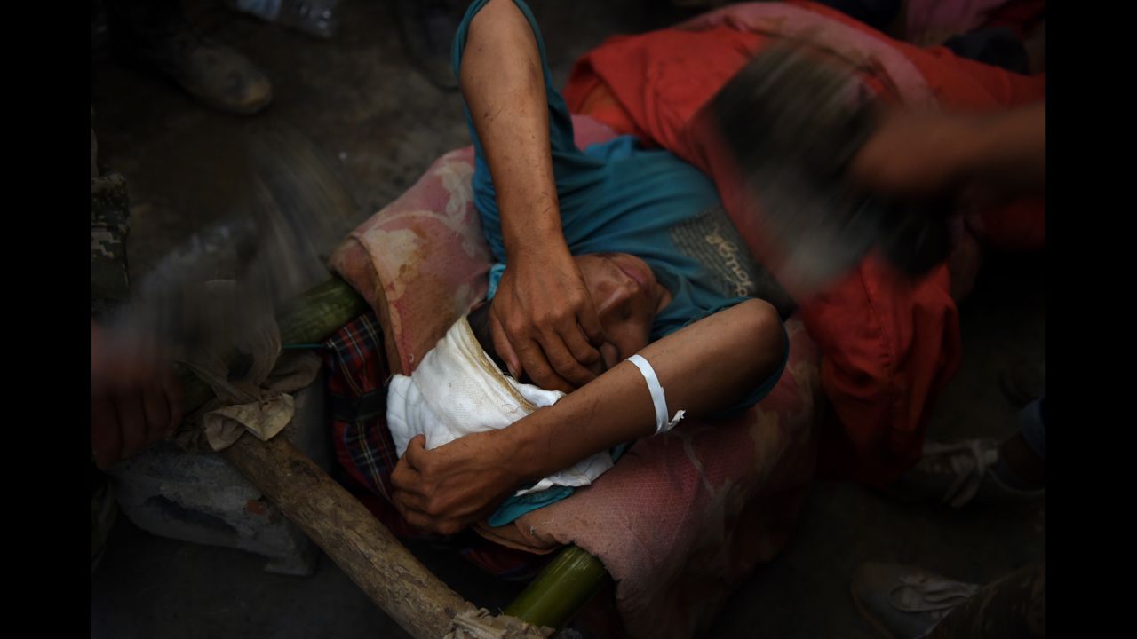 An injured earthquake survivor is fanned while waiting in the corridor of a school before being transferred to an ambulance in Longtoushan on August 6.