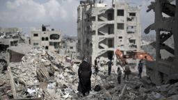 A Palestinian woman walks through the rubble of destroyed buildings in part of Gaza City's al-Tufah neighbourhood as the fragile ceasefire in Gaza entered a second day on August 6, 2014.