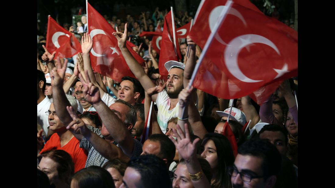 Supporters of Ekmeleddin Ihsanoglu, one of the leading opposition candidates for the presidential election, wave Turkish flags as they listen to him speak during a rally in Ankara on Monday, August 4.