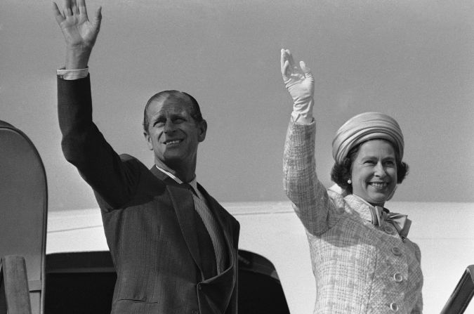 Queen Elizabeth II and Prince Philip wave from a plane ramp shortly before taking off from Tokyo in May 1975.