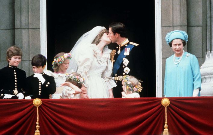 The Queen stands next to Prince Charles as he kisses his new bride, Princess Diana, on their wedding day July 29, 1981.