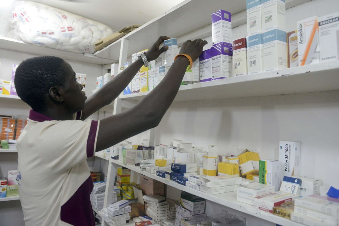 A pharmacist searches for drugs in a pharmacy in Lagos on July 26, 2014.