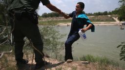 MISSION, TX - JULY 24: A U.S. Border Patrol agent assists an unaccompanied minor, 13, from El Salvador after he crossed the Rio Grande into the United States on July 24, 2014 in Mission, Texas. Tens of thousands of undocumented immigrant families and unaccompanied minors have crossed illegally into the United States this year and presented themselves to federal agents, causing a humanitarian crisis on the U.S.-Mexico border. (Photo by John Moore/Getty Images
