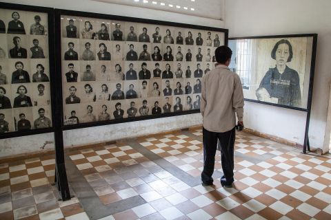 A Cambodian man stands by a wall of photographs of prisoners of the Khmer Rouge regime in one of the rooms of Tuol Sleng prison, also known as S-21, on August 6 in Phnom Penh.