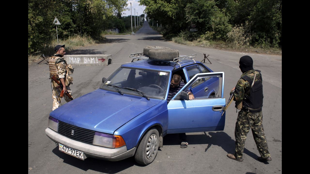 A man steps out of his car as Ukrainian soldiers inspect the vehicle at a checkpoint in Debaltseve on August 6.