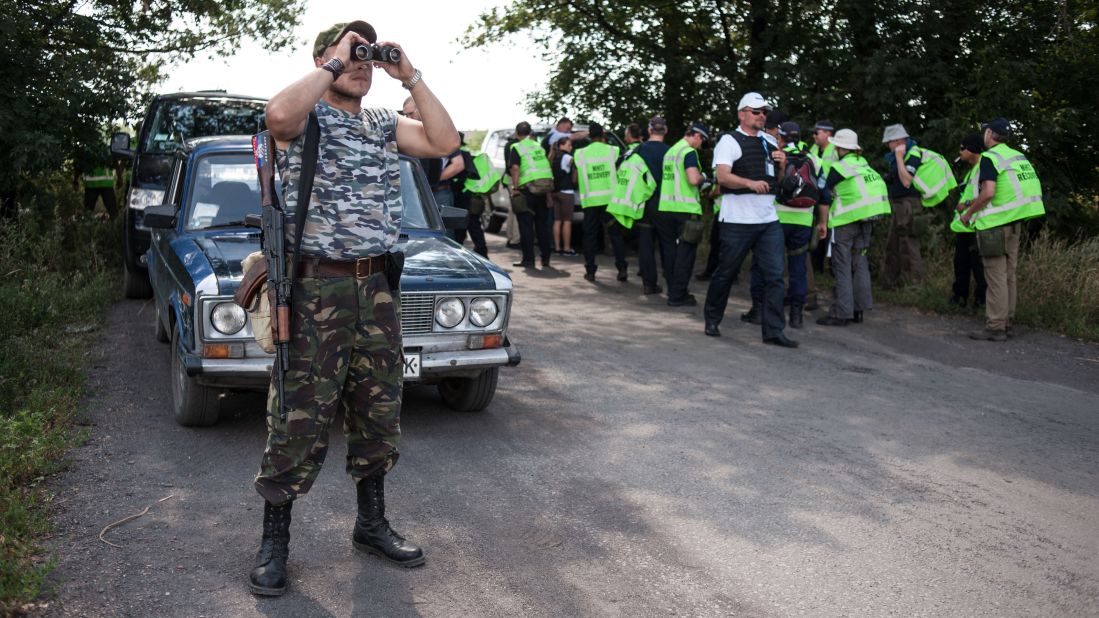 A pro-Russian separatist guards a road as Australian, Malaysian and Dutch investigators prepare to examine the crash site of Malaysia Airlines Flight 17 near the village of Rossipne, Ukraine, on August 5. U.S. and Ukrainian officials allege that a Russian-made missile shot down the plane from rebel-held territory, killing all 298 people on board. Russia and the rebel fighters deny involvement.