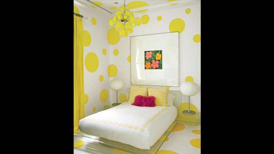 A Warhol "Flowers" work hangs in a guest room that's decked out in a dotted wall treatment devised by Martyn Lawrence Bullard and painted in a Benjamin Moore yellow; the vintage chandelier is by Vistosi, the bedding is by Leontine Linens, and the felt rug is by Anthony Monaco. See more images at <a href="http://www.architecturaldigest.com/celebrity-homes/2014/dee-and-tommy-hilfiger-florida-beach-house-slideshow?mbid=synd_cnn" target="_blank" target="_blank">ArchitecturalDigest.com</a>