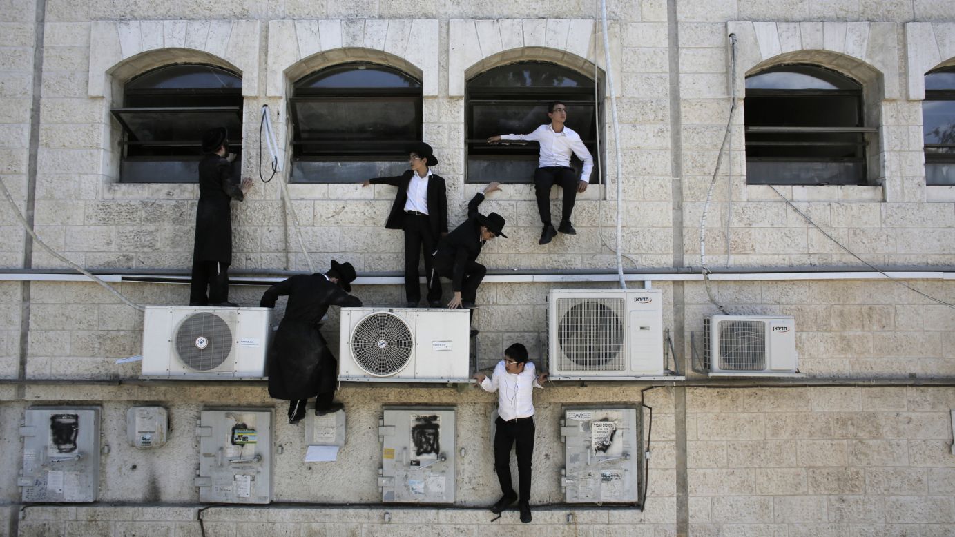 Ultra-Orthodox Jewish boys climb down a wall near the scene of what police described as a terror attack Monday, August 4, in Jerusalem. Police said they shot and killed the Palestinian driver of a construction vehicle <a href="http://www.cnn.com/2014/08/04/world/mideast-crisis/index.html">after it overturned a passenger bus,</a> killing a pedestrian and injuring the bus driver. There were no passengers on the bus during the incident, which appeared to be a backlash against Israel's ground operation in Gaza. Israel <a href="http://www.cnn.com/2014/07/18/world/gallery/israel-gaza/index.html">launched a ground operation in Gaza</a> on July 17, after a 10-day campaign of airstrikes had failed to halt relentless Hamas rocket fire on Israeli cities.