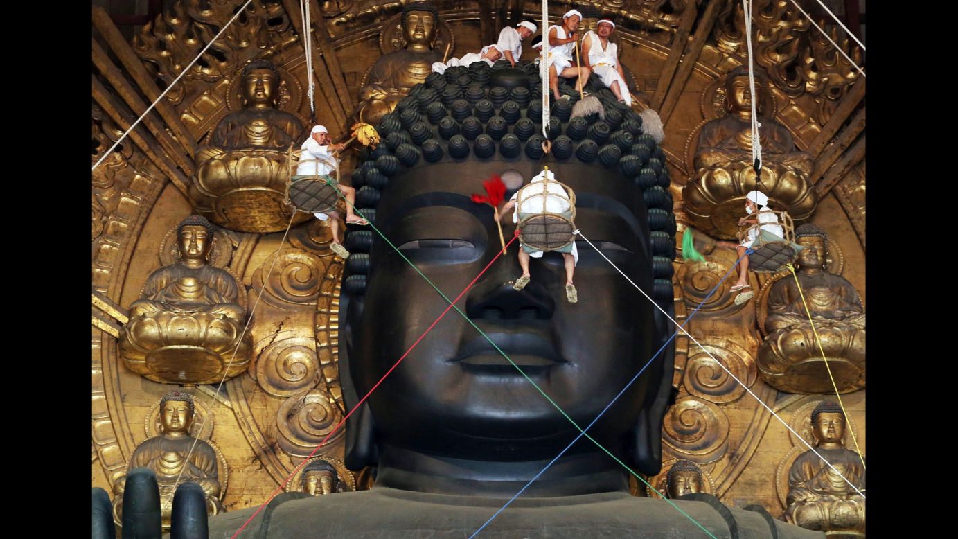 Buddhist monks and volunteers clean a Buddha statue that's nearly 50 feet tall Thursday, August 7, at Todaiji Temple in Nara, Japan.