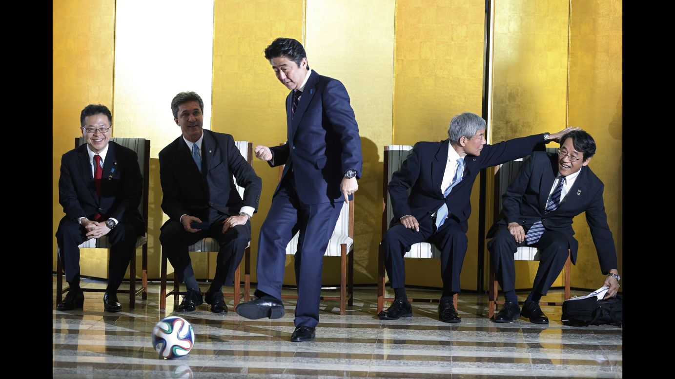 Japanese Prime Minister Shinzo Abe kicks a soccer ball during a meeting with soccer players Friday, August 1, in Brasilia, Brazil.