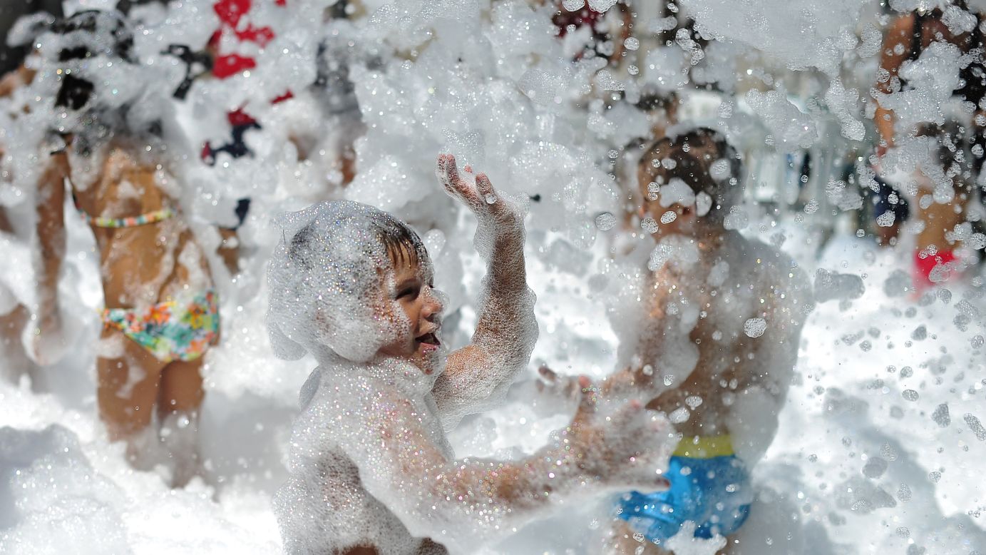 Children play with foamy soap bubbles Sunday, August 3, during a fair honoring "Nuestra Senora de los Angeles" (Our Lady of the Angels) in the village of Las Pinedas near Cordoba, Spain.