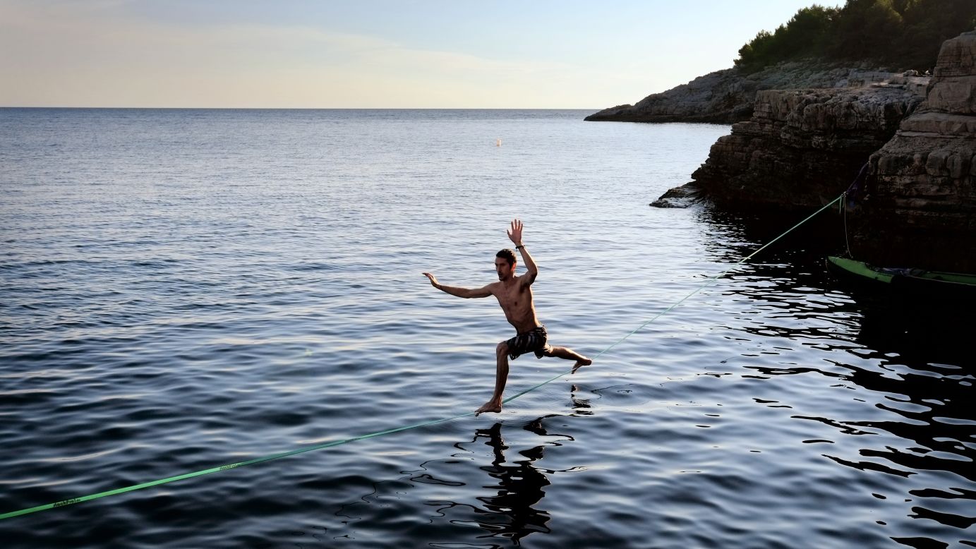 A man balances on a slackline at the cliffs of Stoja near Pula, Croatia, on Tuesday, August 5. The area is known for "deep water soloing," or free climbing over water.