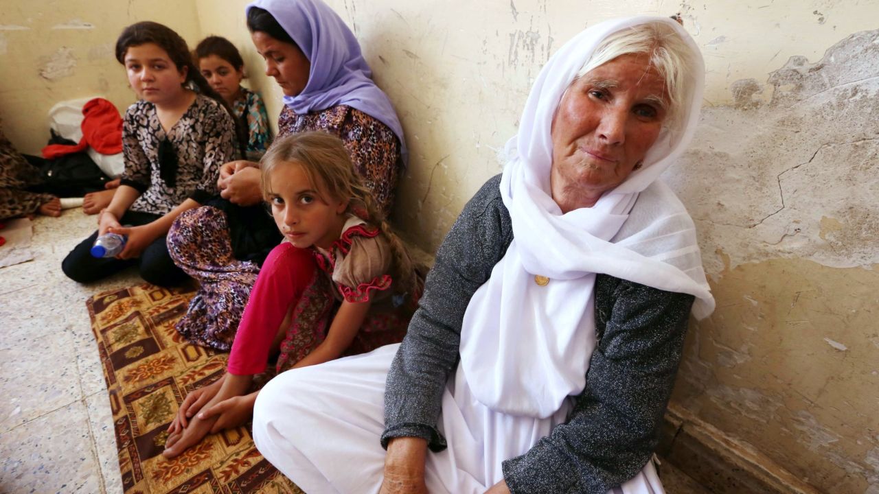 An Iraqi Yazidi family that fled the violence in the northern Iraqi town of Sinjar, sit at at a school where they are taking shelter in the Kurdish city of Dohuk in Iraq's autonomous Kurdistan region, on August 5, 2014. Islamic State (IS) Sunni jihadists ousted the Peshmerga troops of Iraq's Kurdish government from the northern Iraqi town of Sinjar, forcing thousands of people from their homes. The Yazidis, are a small community that follows a 4,000-year-old faith and have been repeatedly targeted by jihadists who call them 'devil-worshipers' because of their unique beliefs and practices. AFP PHOTO/SAFIN HAMED (Photo credit should read SAFIN HAMED/AFP/Getty Images)