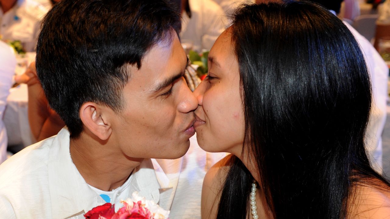 A newlywed couple kiss at a wedding ceremony in Manila on Valentine's Day last year.