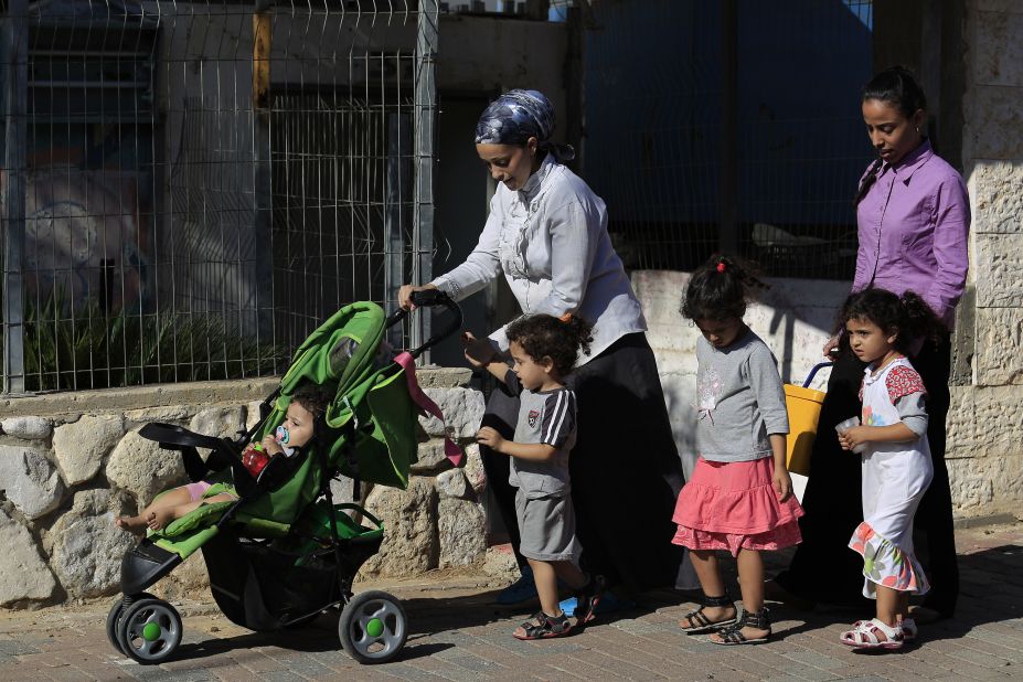 Israelis flee after a rocket fired from Gaza hit the residential neighborhood of Sderot, Israel, on August 8.