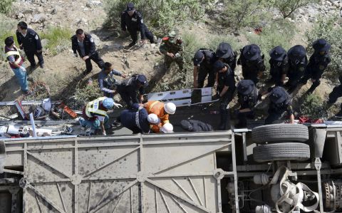 Rescuers work to pull victims from an overturned tour bus after it fell off a cliff in Nyemo County, Tibet, on Saturday, August 9. 