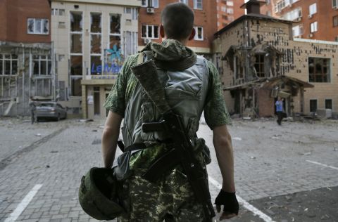 A pro-Russian rebel inspects damage after shelling in Donetsk on Thursday, August 7.
