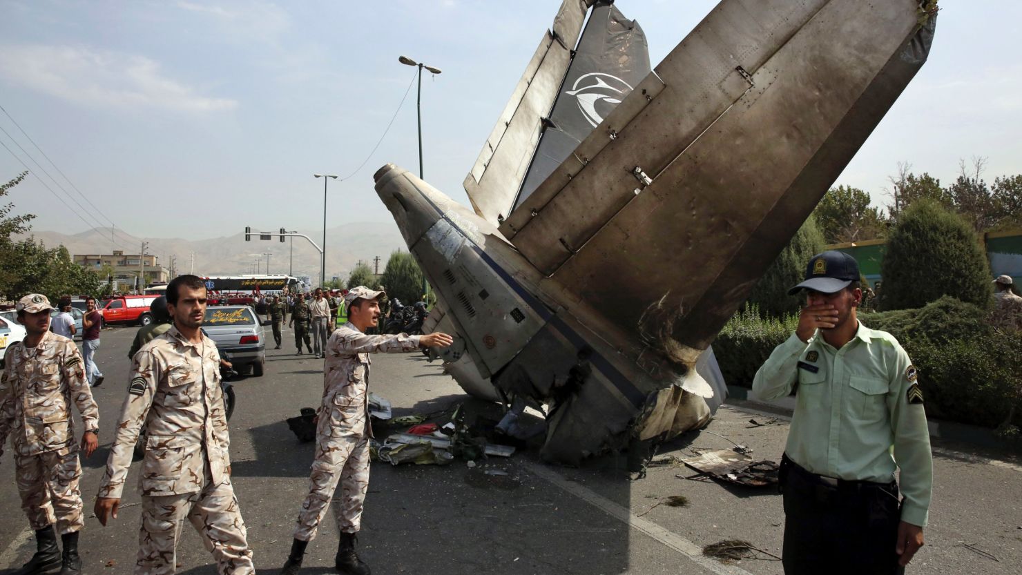 Iranian Revolutionary Guards and police officers inspect the site of a passenger plane crash in Tehran, Iran's capital.