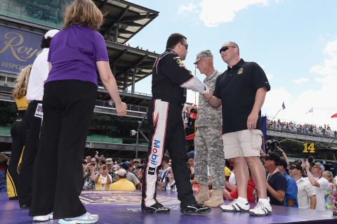 Stewart shakes hands with a member of the military at the Indianapolis Motor Speedway in July 2013.