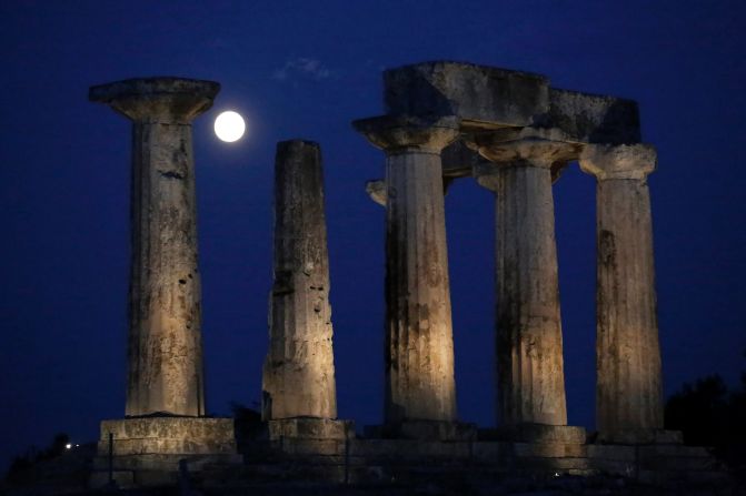 The moon appears behind Apollo's Temple at ancient Corinth, southwest of Athens, Greece. 