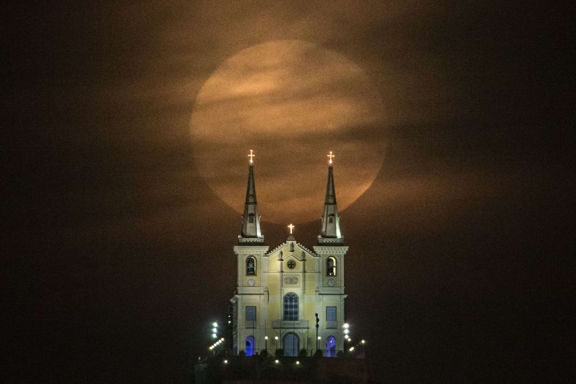 The moon descends behind the Nossa Senhora da Penha Church in Rio de Janeiro.