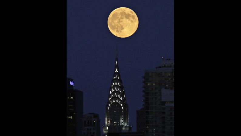 The moon appears over the New York skyline in a view from Weehawken, New Jersey, on August 10.
