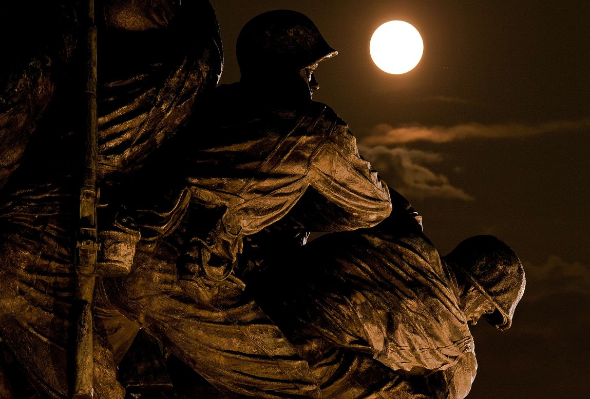 The moon rises above the U.S. Marine Corps War Memorial in Arlington, Virginia.