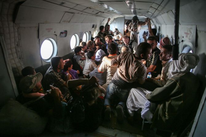 Yazidi people sit on the aircraft with members of the CNN crew.