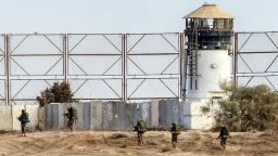 Caption:Israeli soldiers walk past a fence along Israel's border with the Gaza Strip, on August 4, 2014. An eight-year-old girl was killed and 30 people wounded in a strike on the beachfront Shati refugee camp in Gaza City just minutes into an Israeli-declared truce, medics said. AFP PHOTO / JACK GUEZ (Photo credit should read JACK GUEZ/AFP/Getty Images)