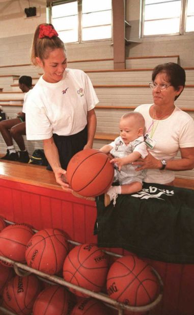 Hortencia played in the Atlanta Games despite giving birth to Joao just five months earlier. Then 36, she is pictured introducing baby Joao (and his nanny) to basketball during a training session ahead of the 1996 Olympics.