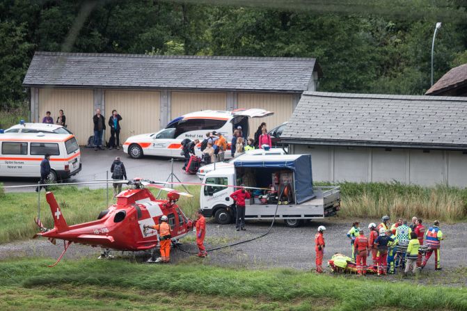 At right, rescue forces recover a victim of the derailment.