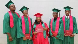 Michael Brown (far left), the teen shot and killed by Ferguson, Missouri police August 9, 2014, stands with fellow graduates at Normandy High School Summer graduation. The May class had 120 graduates, the summer class had 11 graduates.
MUST CREDIT:  Normandy Schools Collaborative/Daphne J. Dorsey
