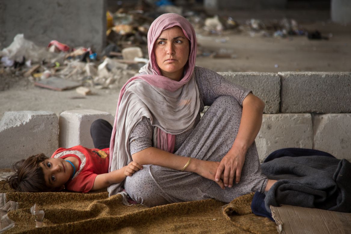 A woman and child sit in the makeshift housing on Thursday.