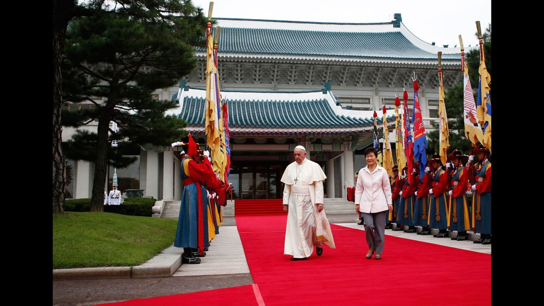 Pope Francis walks with South Korean President Park Geun-hye before a welcoming ceremony at the presidential Blue House in Seoul on August 14.