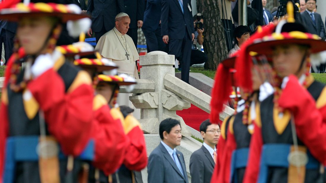 Pope Francis walks down stairs during a welcoming ceremony in Seoul.