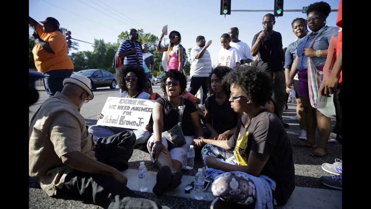 A small group of protesters block traffic in the street before police arrived on August 13, 2014.