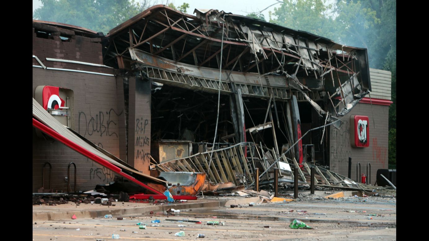 A burned-out QuikTrip gas station smolders on August 11, 2014 after protesters looted and burned the Ferguson building the night before.
