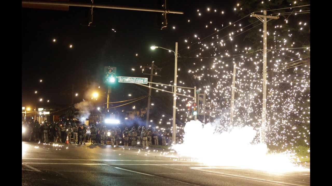 A device deployed by police goes off in the street as police and protesters clash Wednesday.