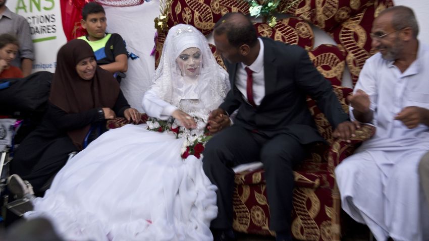 Omar Abu Namar, 30, (R) and his wife Heba Fayad, 23, (L) attend their wedding ceremony at a UN school school in Gaza City's Shati refugee camp on August 13, 2014.